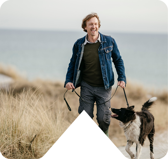 man walking dog on beach